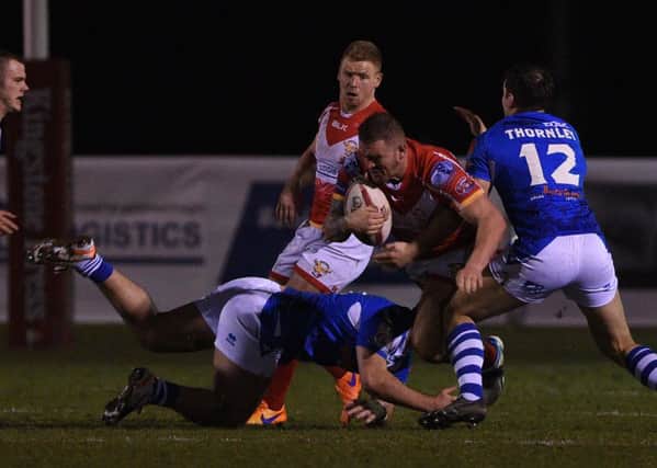 Sheffield Eagles' Mitch Stringer tries to break through against Swinton Lions, with Keal Carlisle in the background.