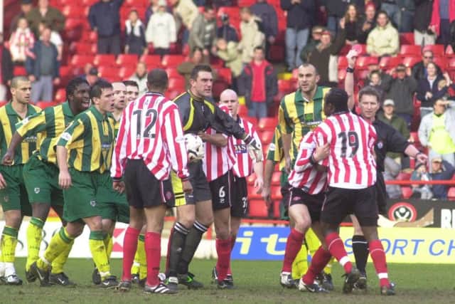 Patrick Suffo is held back by players.