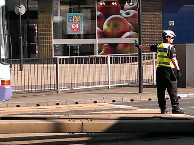 A policewoman directing traffic after a bus broke down on Trafford Way