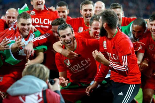 Gareth bale celebrates qualification with his Wales team mates