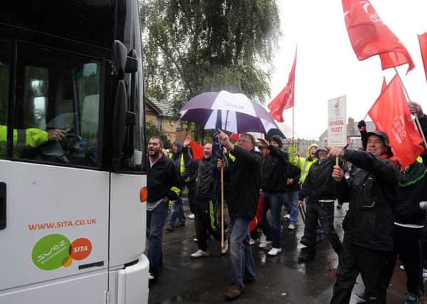 Unite members stand infront of a bin truck and wave their flags as they are on strike, and successfully make the bin truck turn back into the depot. Picture: Andrew Roe