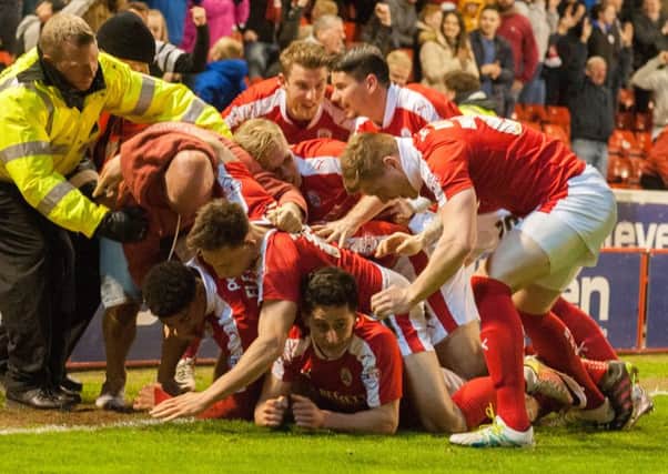 Barnsley's George Williams is jumped on by his team mates after scoring in the last minute. 
Picture Dean Atkins