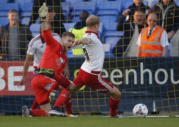 George Long and Jay McEveley combine to clear the ball after the former's penalty against Shrewsbury