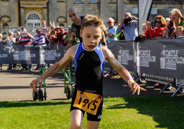 Bailey Matthews from Doncaster crosses the finish line  to complete his first ever triathlon at Castle Howard last year.