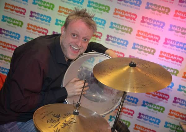 Big John with a drum kit signed by some of the world's top bands for Superhero Day