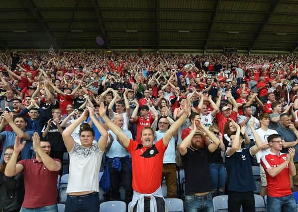Barnsley fans go wild as they clinch their play-off place with a  4-1 at champs Wigan . Photo: Keith Turner
