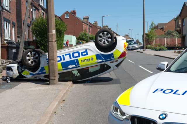 A police car rests on it roof after an RTC on Carlton Road in Barnsley, South Yorkshire Picture Dean Atkins