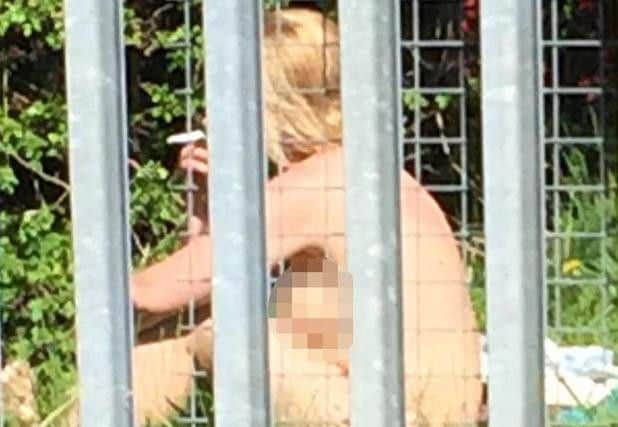 The naked woman smokes a cigarette after the sex session.