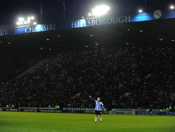 Barry Bannan on the pitch at Hillsborough as the crowd lights up around him