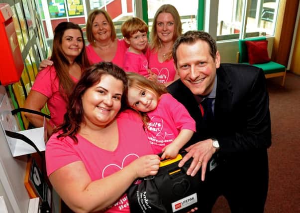 Matthew Whinson, headteacher of William Levick Primary School, with  (front) Sammy Mellor and Heidi Mellor, and (back l-r) Stacey Smith, Hazel Smith, Elliot Price and Lisa Price, where a defibillator has been installed as part of trying to raise awareness through a charity Hand on Heart, as Heidi was born with long qt syndrome. Picture: Andrew Roe
