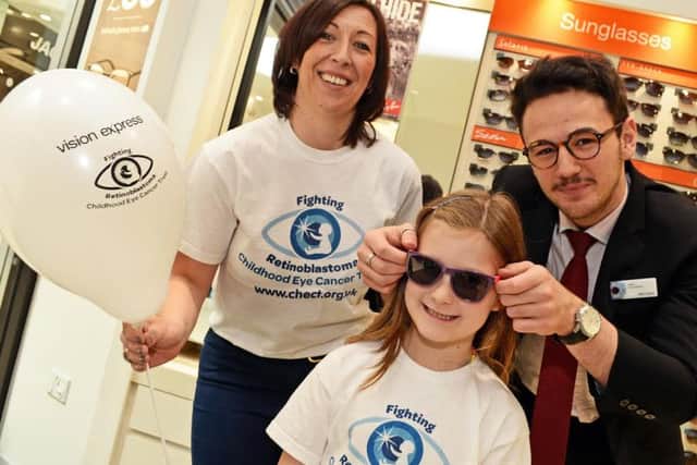 Jane Harrison and her daughter Olivia, seven, CHECT Ambassador, pictured with Viktor Tulev, Optical Apprentice, during the  launch the stores Sunglasses giveaway during World Retinoblastoma Awareness Week.