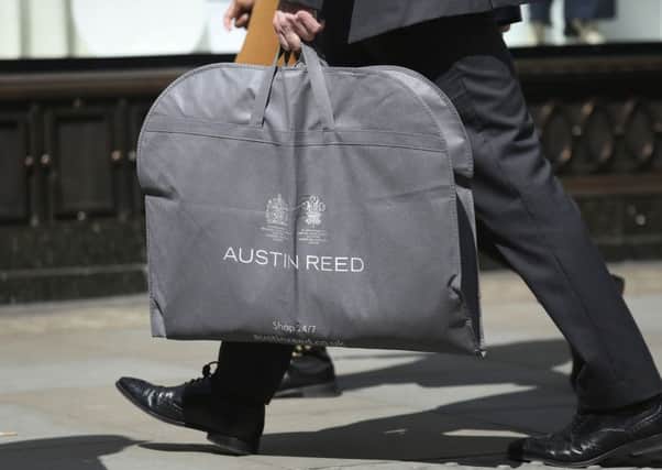File photo dated 26/04/16 of a man carrying an Austin Reed bag, as the chain is to close 120 stores, resulting in the loss of approximately 1,000 jobs, administrators have said. PRESS ASSOCIATION Photo.