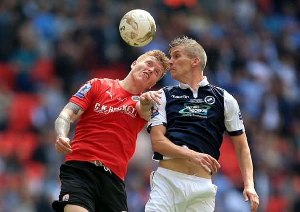Barnsley's Alfie Mawson (left) and Millwall's Steve Morison battle for the ball during the Sky Bet League One Play-Off Final at Wembley