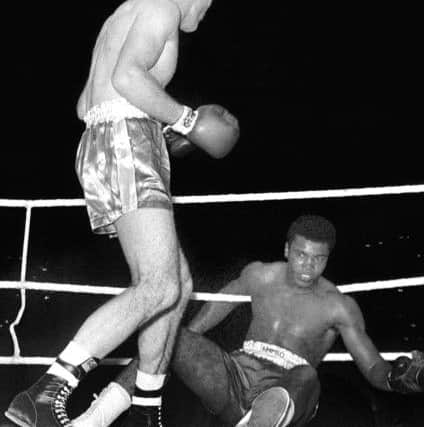 British heavyweight boxer Henry Cooper during his fight at Wembley in London, as he floors boxing legend Muhammad Ali (right), who has died at 74. PRESS ASSOCIATION Photo.