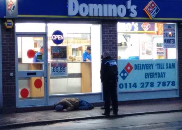 A police officer attends to a street drinker outside Domino's on West Street in Sheffield city centre. Residents claim people getting drunk and high on drugs are ruining the area as plans for a third off-licence goes to Sheffield Council planning committee - Photo: Sheffield City Centre Residents' Action Group
