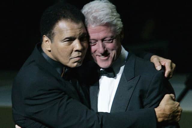 Muhammad Ali, left, hugs former U.S. President Bill Clinton as he walks onstage at the grand opening gala celebration for the Muhammad Ali Center in Louisville. Clinton will deliver the eulogy at Alis funeral