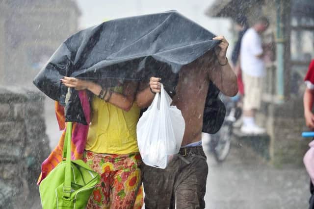 A a couple caught up in a brief summer downpour, as short, sharp downpours could become an increasingly unwanted characteristic of the British summer. Ben Birchall/PA Wire