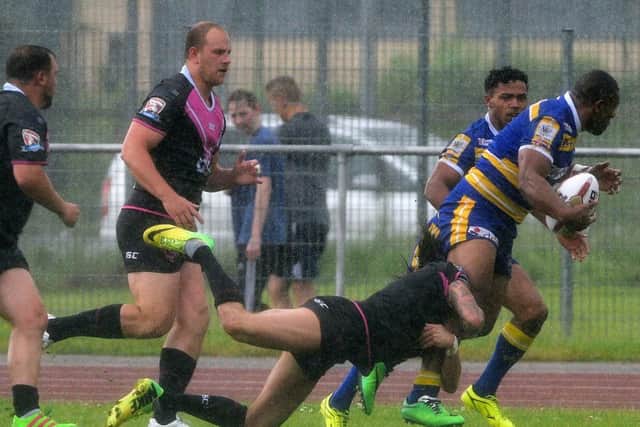 Jason Tali looks to break the South Wales line for the Dons