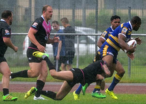 Jason Tali looks to break the South Wales line for the Dons