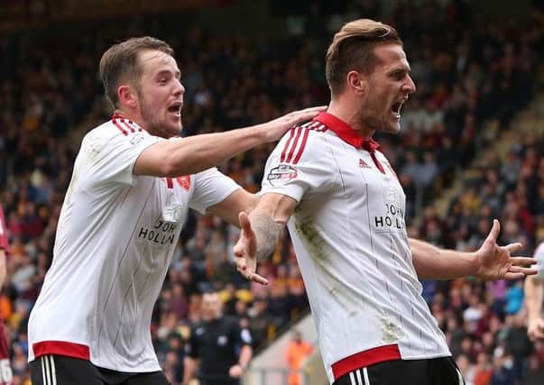Marc McNulty congratulates Billy Sharp on a goal for United -  these two are among the men whose goals can win promotion.  Photo: Sportimages