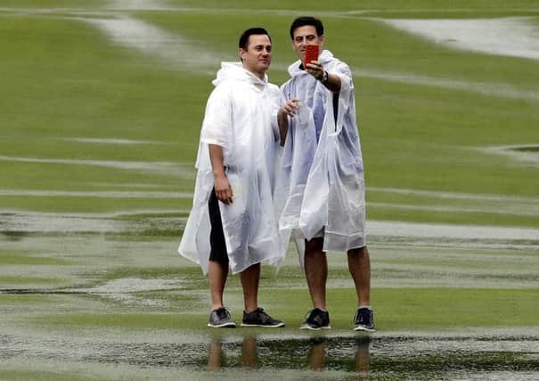 Fans pose for selfies among the puddles at the weather-ravaged US Open