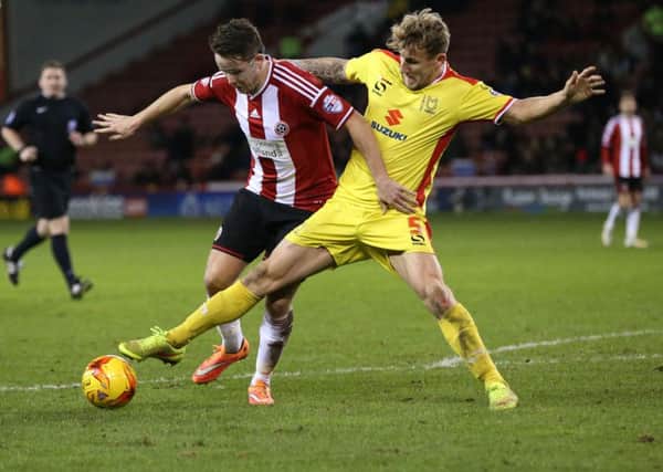 Kyle McFadzean, pictured in action for MK Dons against Uniteds Marc McNulty