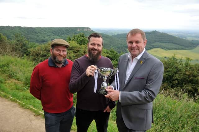 30 June 2016.......      Sir Gary Verity, Chief Executive of Welcome to Yorkshire, presents the Tour de Yorkshire Land Art trophy to sheffield Artists at the Landmark Collective, James Brunt and Timm CORRECT Cleasby  for their work entitled The Finest View.
The 70-metre high, 40-metre wide painting on the grassy airfield at the Yorkshire Gliding Club at Sutton Bank beat off fierce competition from 11 other finalists to be crowned the 2016 winner. It showed animals on a penny farthing looking out over what James Herriot called the finest view in England. Picture Tony Johnson.