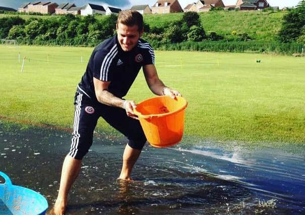 Billy Sharp mucks in with the water removal