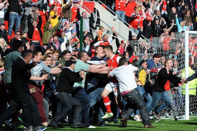 Engulfed by fans as he seals promotion to League One