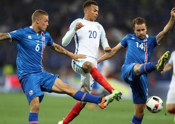England's Dele Alli (centre) in action with Iceland's Ragnar Sigurdsson (left) and Kari Arnason during the Round of 16 match at Stade de Nice