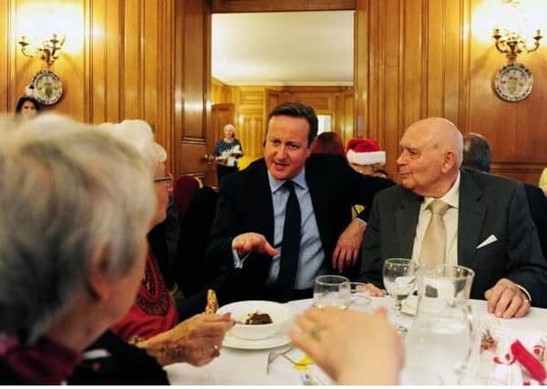 Former Prime Minister David Cameron speaks to residents who attend friendship lunches.