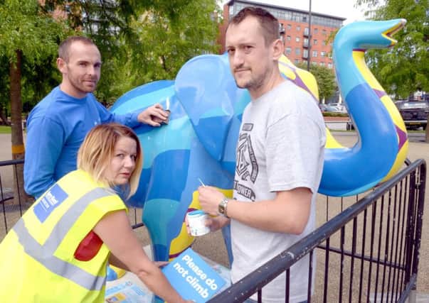 Damage to The Herd being repaired on Devonshire Green. Rebecca Staden, herd project manager is pictured with Mick Kay from Mint Motors who is doing fiberglass repairs and Artist Rob Lee by the elephant Technicolour Pachyderms.