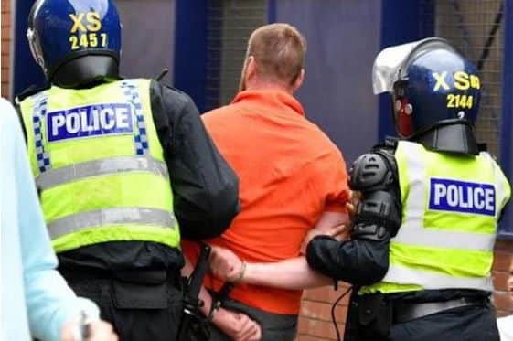 Sheffield United fan Brett Houlsworth from Intake is lead away by officers after throwing a can of Vimto over a police inspector. He admitted the offence at Grimsby Magistrates' Court and was handed a three-year banning order - PICTURE: ROSS PARRY/SWNS