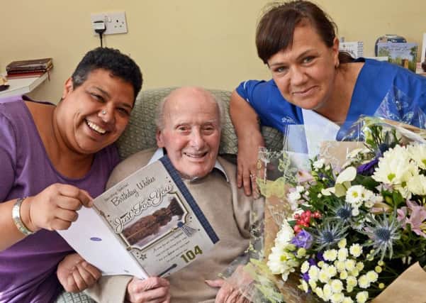 Cecil Higgins celebrating his 104th birthday at Grange Crescent Residential Care home with Asha Oliver, care home manager, and Kay Leng, key worker
