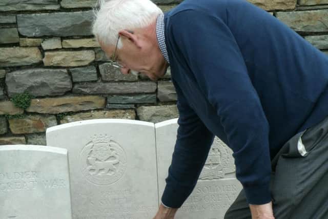 Peter Swift places a wreath, with a photo of the baby that his relative never saw, on Stuart Swifts grave