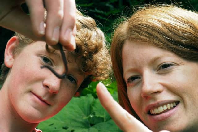 Zoe Stevens from the National Trust and Max Killen examine an earthworm