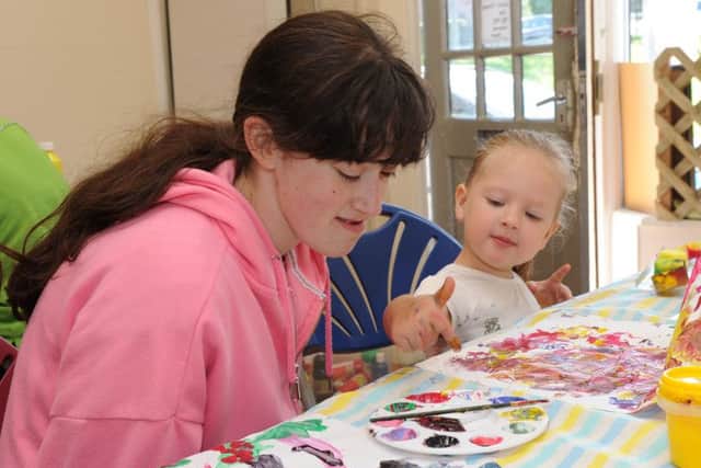 Loren Hutchinson helps Kathryn Wilford paint at an activity session at the Link. Picture: Andrew Roe