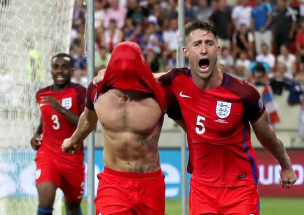 England's Adam Lallana (centre left) celebrates scoring his side's goal with teammate Gary Cahill (right) during the 2018 FIFA World Cup Qualifying match at the City Arena, Trnava.