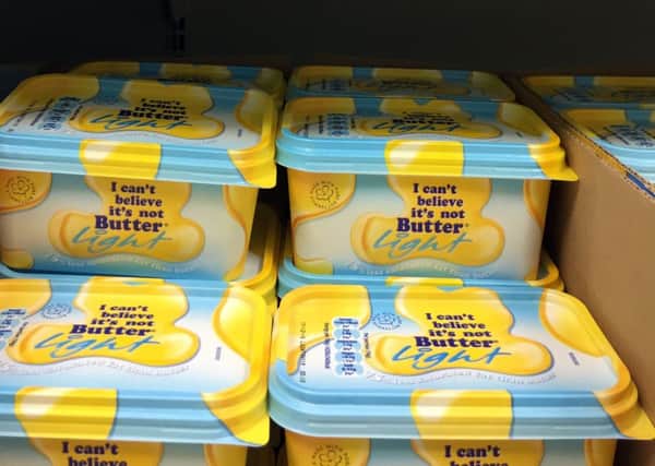 Tubs of 'I can't believe it's not butter' on a shelf in a Tesco store