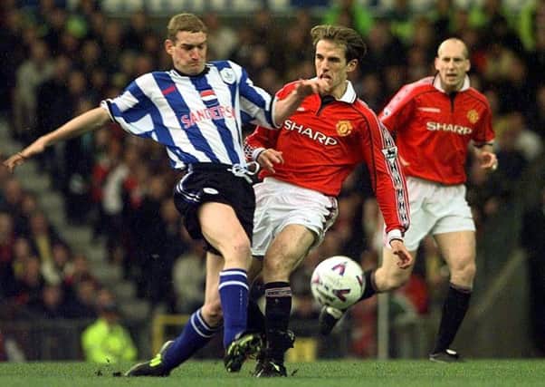 Sheffield Wednesday's Andy Booth (left) tackles Manchester United Phil Neville during their FA Premiership clash at Old Trafford. PA photo: John Giles.
