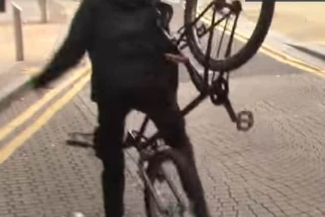 A cyclist is sent flying from his bike in Mulberry Street after being pied. (Photo: YouTube).