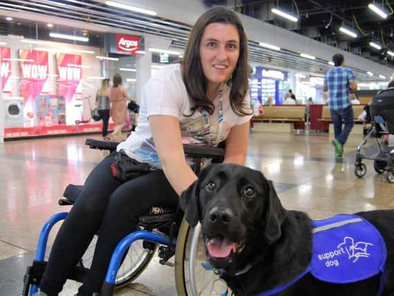 Black labrador Stanley is trained to pull an alarm to call for help every time Amy Williams has an epileptic seizure. Photo: Support Dogs