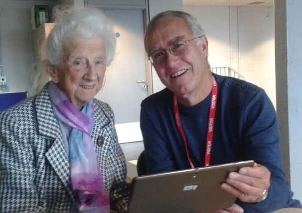 Kathleen Mysberg with Age UK Sheffield digital inclusion volunteer Paul Leman and her tablet device which she has learned to use to video call relatives