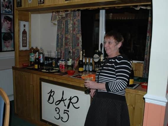 The homes administrator Sue Mellor enjoys a drink at the bar.