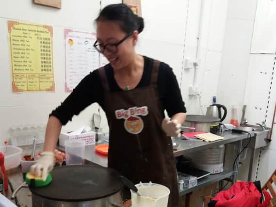 Ms Zhang Ge, 26, making 'Chinese crepe' at Big Bing in the Moor Market, Sheffield