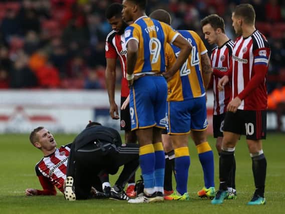 Paul Coutts receives treatment after a challenge from Abu Ogogo which saw the Shrewsbury Town player sent off