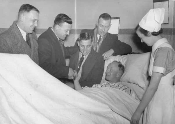 George Milburn, Harry Brown, Harry Clifton and Allan Sliman stand at the bedside of Joe Devine, after the Chesterfield half-back broke a leg against Spurs in the FA Cup fifth-round tie in February 1938.