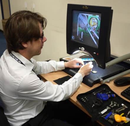 Kyle Crossland, Information Officer, using his desktop magnifier, funded by Access to Work.