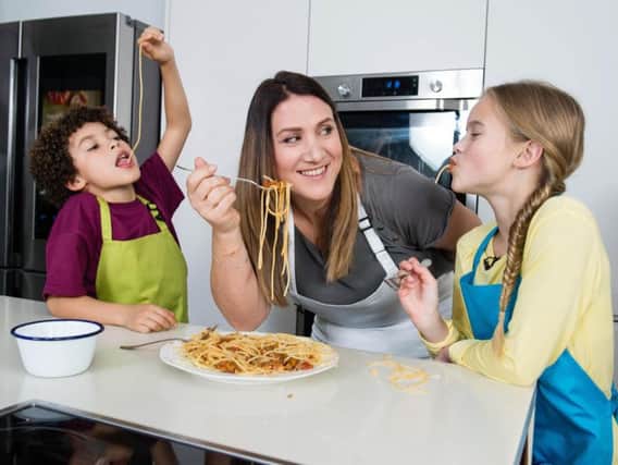 MasterChef finalist Emma Spitzer teaches Harvey, 9, and Hattie, 10, to make some of the top 25 recipes children should be able to cook by the age of 11. Photo: Jeff Spicer/PA Wire