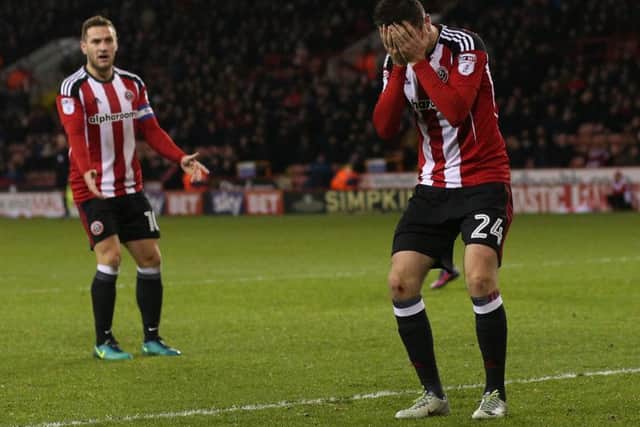 Danny Lafferty puts his head in his hands after missing a big chance for the Blades while Billy Sharp shows his frustration